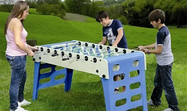 Kids playing outdoor foosball.